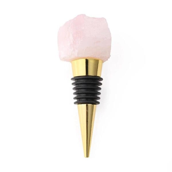A pink quartz crystal attached to a golden wine bottle stopper, displayed against a white background.