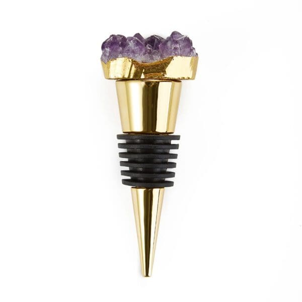 Gold bottle stopper with a purple amethyst crystal top against a white background.