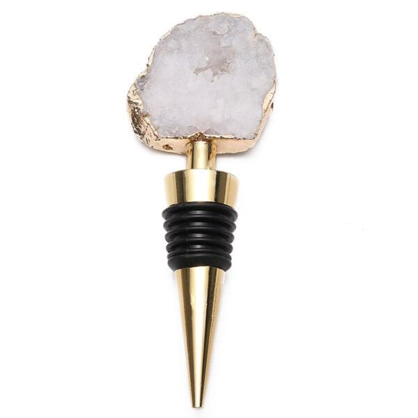 A wine stopper featuring a gold cone base with black rubber rings, topped with a rough-edged, crystalline white geode.