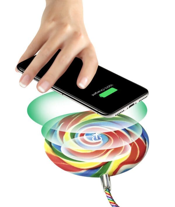 A hand placing a smartphone over a vibrant, swirling lollipop that emits colorful circles, symbolizing wireless charging or data transfer.