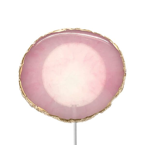 Circular pink and white agate slice on a metal stand with gold edges, isolated on a white background.