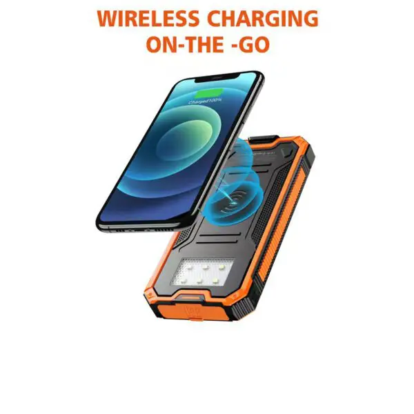 Smartphone wirelessly charging on a rugged, orange portable charger with built-in solar panel and led light.