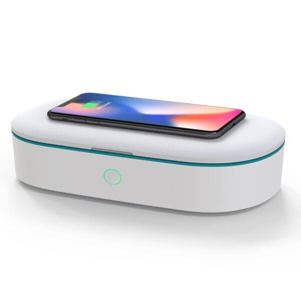 Smartphone charging on a white uv sanitizer box with a glowing indicator light.