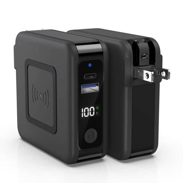 Portable black battery generator with digital display showing 100% charge, multiple outlets, and wireless charging pad.