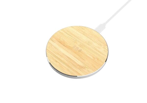 Round wireless charger with a bamboo top surface and a white usb cable, isolated on a white background.