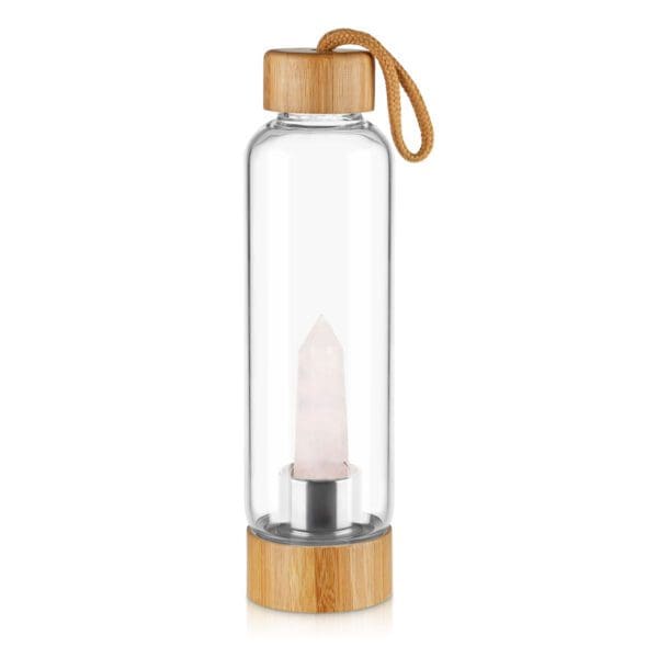 Clear water bottle with a rose quartz crystal inside, capped with a bamboo lid and featuring a brown carrying loop, isolated on a white background.