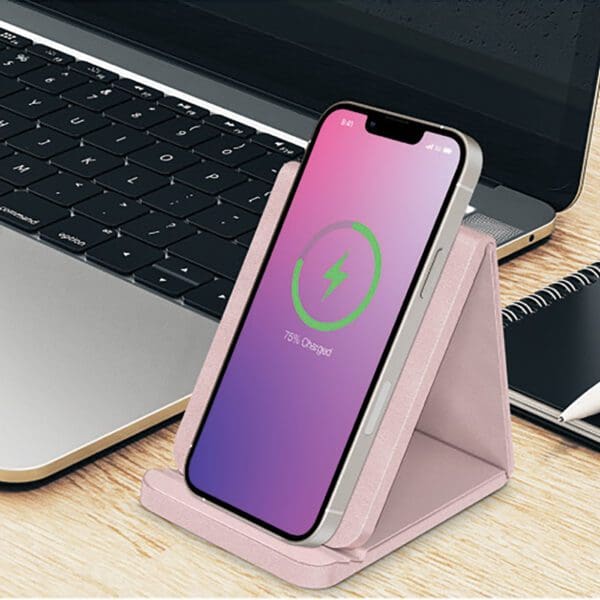 A pink phone holder sitting on top of a desk.