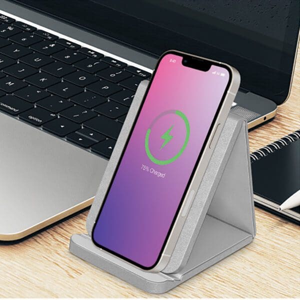 A wireless charger is sitting on the side of a laptop.