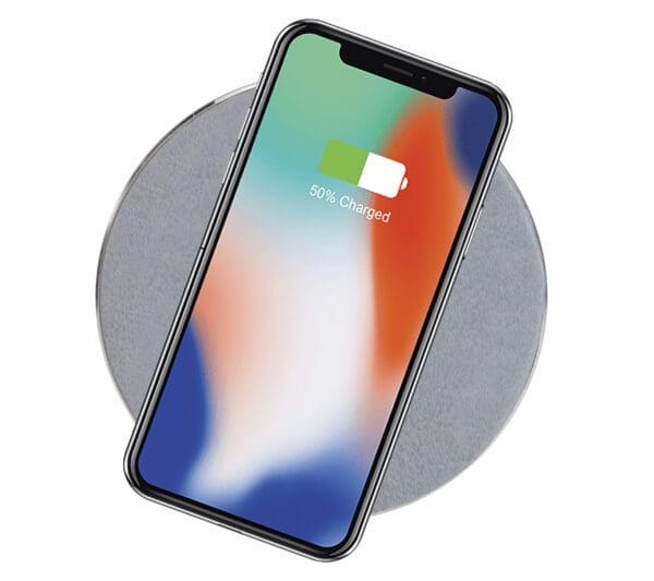 Smartphone on a wireless charging pad displaying a 50% charged battery screen.