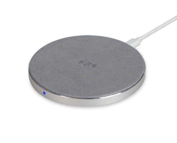 Round wireless charging pad with a gray fabric top and metal edge, connected by a white cable, with an active blue indicator light.