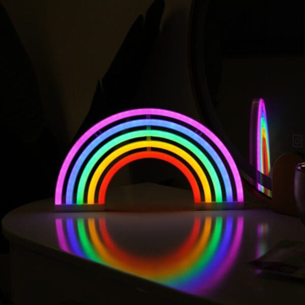 A colorful led rainbow light illuminating a dark room, casting vibrant reflections on a white surface.