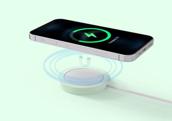 Smartphone on a wireless charging pad with a charging icon displayed on the screen, set against a soft green background.