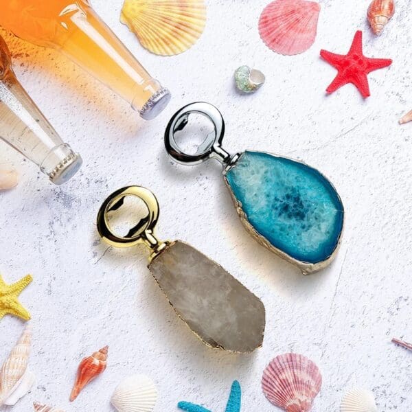 Two elegant agate slice bottle openers on a surface decorated with seashells, starfish, and two bottles.