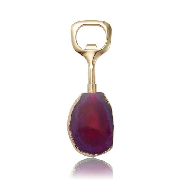 Gold bottle opener with an elongated handle, featuring a large, purple agate stone as the grip.