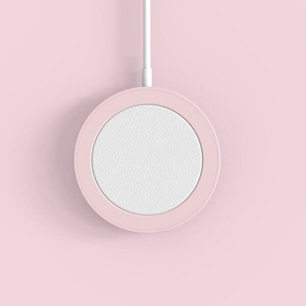 A pink wireless charger suspended on a pink background, viewed directly from above.