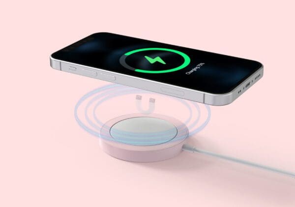 Smartphone charging on a wireless charging pad with a charging symbol on screen, set against a soft pink background.