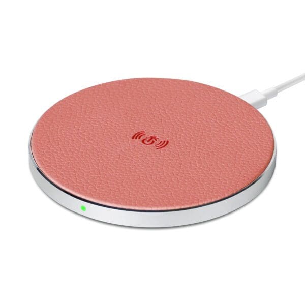 A pink leather-textured wireless charging pad with a cable plugged in, set against a white background.
