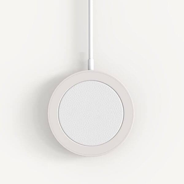 A white, circular wireless charging pad suspended from a white cable against a clean, white background.