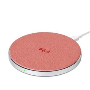 Round pink textured wireless charging pad with a cable connected on the left and a small green indicator light on.