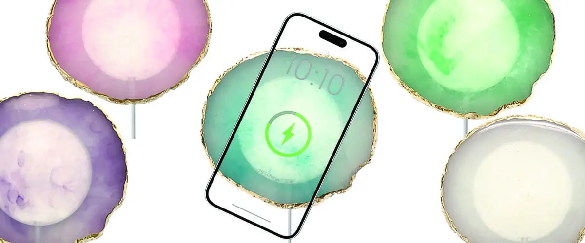 A smartphone displaying a charging icon, surrounded by colorful, translucent agate slices with gold edges.