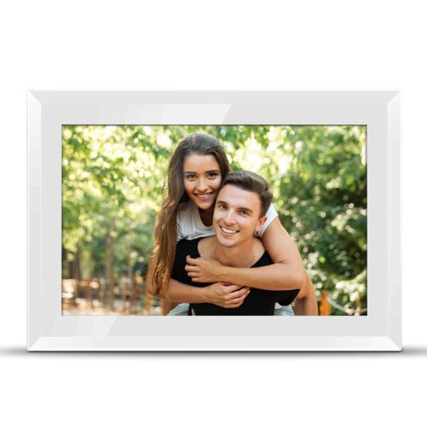 A Digital Picture & Video Frame of a happy young couple piggybacking in a sunlit wooded area, smiling at the camera.