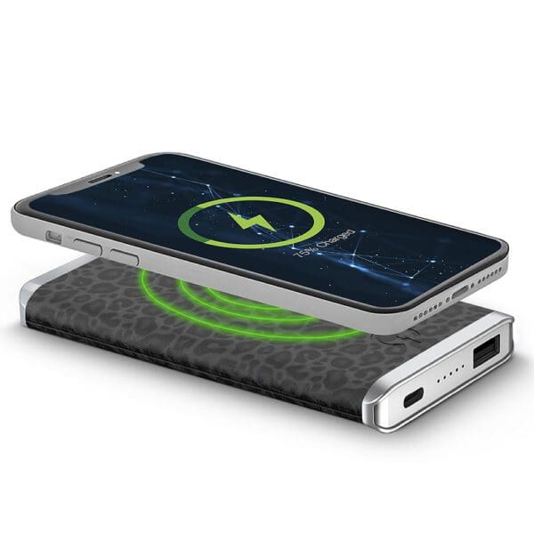 Smartphone charging on a Houndsooth - Leather 5K Wireless Charging Power Bank with a glowing green light indicating charging status.