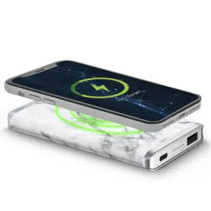 Smartphone lying on a Houndsooth - Leather 5K Wireless Charging Power Bank with a glowing green light, indicating charging status.