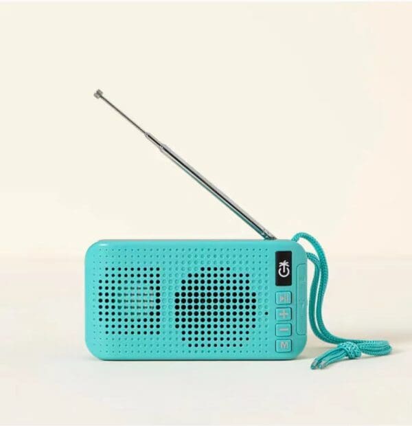 A teal solar powered wireless speaker with an extended antenna and a carrying loop on a plain light background.