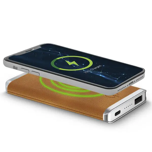 Smartphone with a charging symbol on screen, resting on a Leather Wireless Charging Power Bank with a green glow.